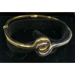 A 9ct yellow and white gold hinged bangle. 6.7gms.Condition ReportGood condition