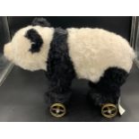 A Steiff panda on brass wheels with growler mechanism. 55 l x 39cms h. No. 400452Condition