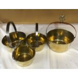 Four brass jam pans comprising a graduating set of three, 27cms, 25cms and 21cms together with a