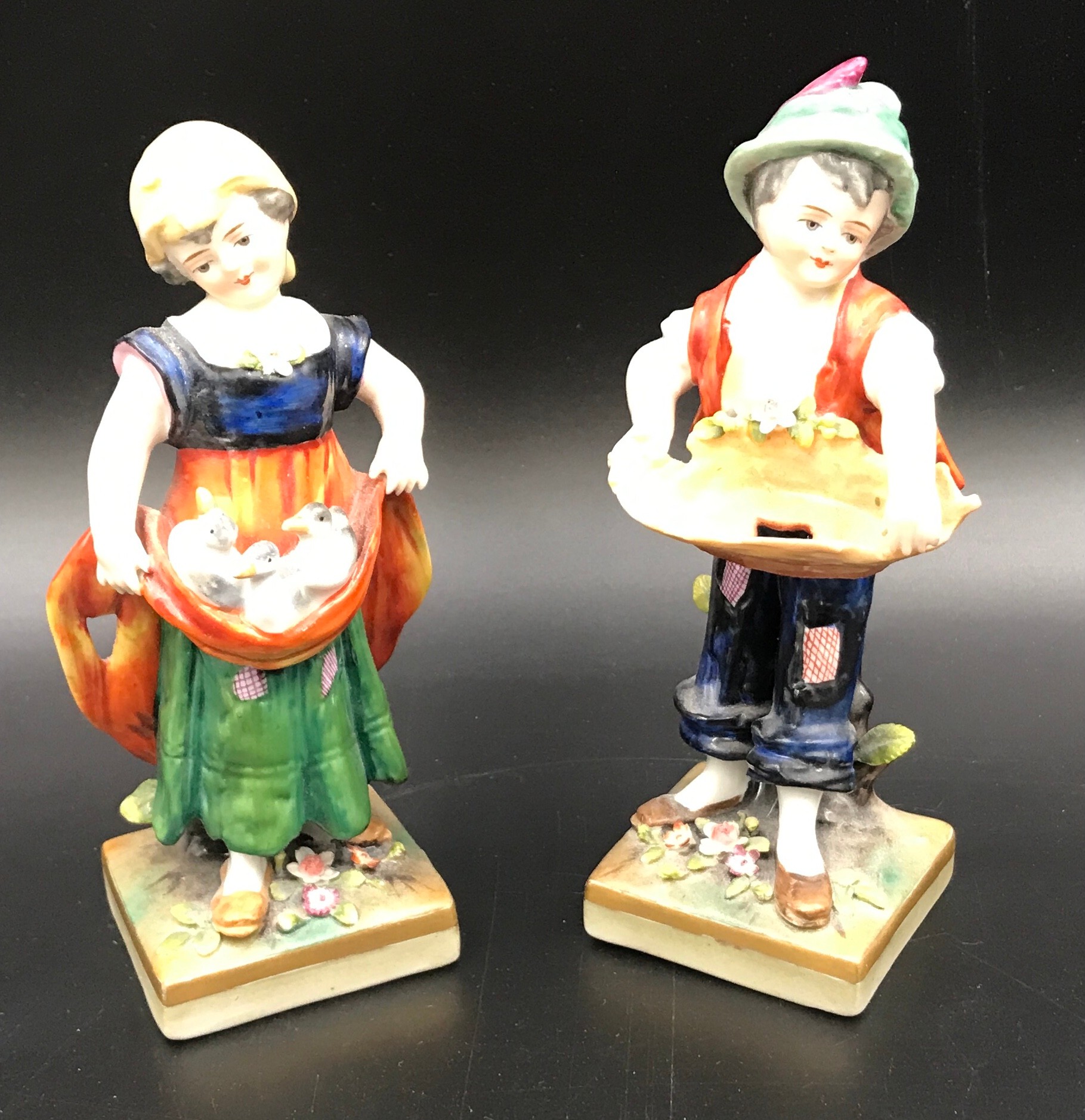 A pair of Sitzendorf figurines, boy 14.5cms h, girl with ducks 14cms h.Condition ReportMinor chips