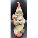 A vintage reconstituted stone pipe smoking gnome astride a log. 48cms h.Condition ReportWear to