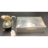 Silver cigarette box 9 x 18cms. 564gms total. With an unmarked white metal creamer 77gms.Condition