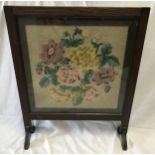 An oak framed firescreen with floral wool work panel. 66cms h x 53cms w.Condition ReportGood