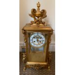 A French visible escapement clock with a mercury pendulum in brass and glass face with key. 44.