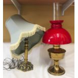 A brass oil lamp with red glass shade 61cms x 26cms w approx. together with a brass table lamp 29cms