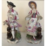 A pair of Continental painted figurines of a man and woman both with dogs. 16cms h. Condition