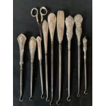Nine hallmarked silver button hooks, various dates and makers and silver handled scissors,