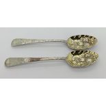A composed pair of Georgian silver gilt berry spoons, London 1824, maker CE and 1813, makers mark