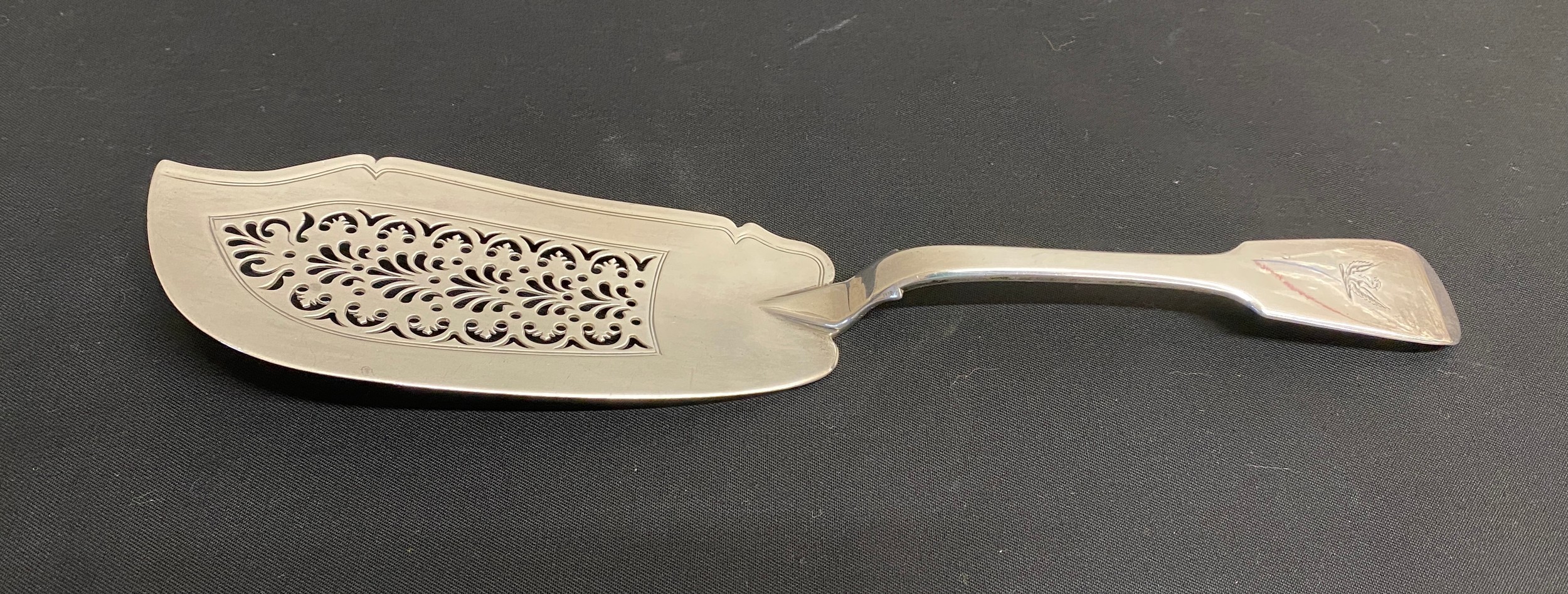 A hallmarked pierced silver fish slice London 1830 John, Henry & Charles Lias. Crest to handle.