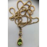 A 9ct yellow gold chain 41cms l with green and clear stone drop pendant. Weight 3.3gms.