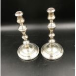 A pair of silver weighted candle sticks, London 1927 R&C. Measures 27cms h x 15cms base width.