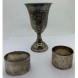 Two hallmarked silver napkin rings together with a white metal goblet. Total weight 123gms.Condition