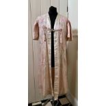 A good quality Chinese embroidered silk robe with lace up sides, gathered capped sleeves and tassels