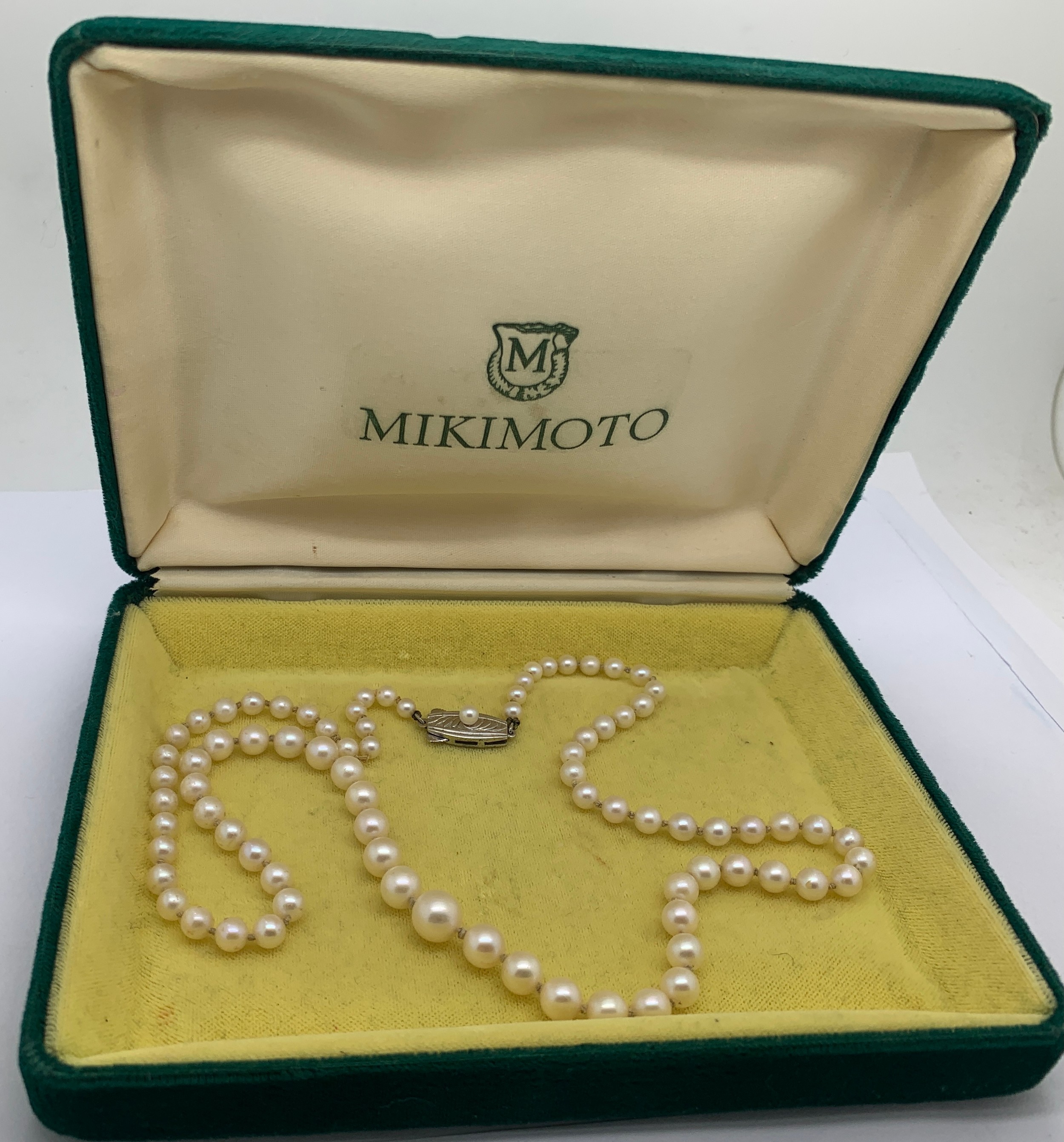 A Mikimoto single strand necklace of graduated pearls with a white metal clasp. 52cms l.Condition