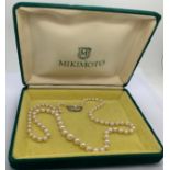 A Mikimoto single strand necklace of graduated pearls with a white metal clasp. 52cms l.Condition