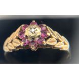 A 9ct gold ring set with pink stones surrounding a diamond chip. Size Y/Z. Weight 2.7gms.