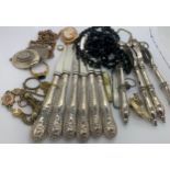 A miscellany to include silver handled knives, nutcrackers, french jet beads, a 9ct gold clasp etc.