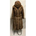 A long light brown mink coat with belt and beret style matching hat. Embroidered initials to right