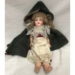 A German porcelain headed doll with original clothing and open/close eyes. 34cms h.Condition