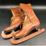 A pair of leather lace up ice skating boots with leather blade protectors by Manfield & Sons Ltd