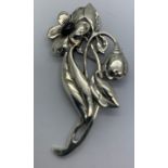A white metal flower brooch set with cabochon cut red stone. 6 x 3cms.Condition ReportMarks to