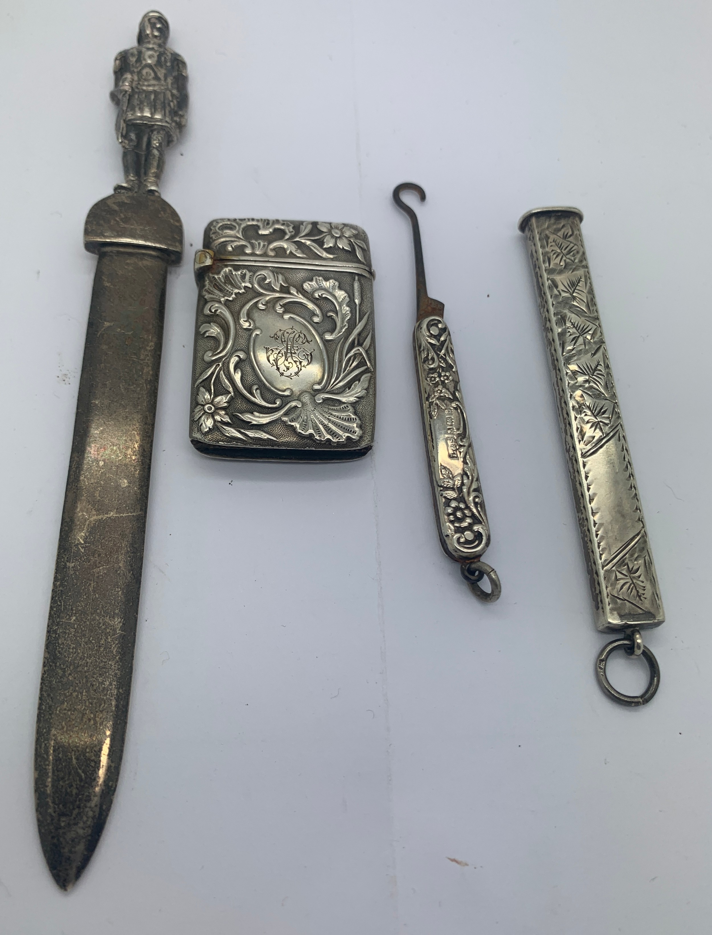 Four various silver and white metal items to include a paperknife, a button hook Birmingham 1901,