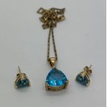 A Topaz pendant on a 9ct gold chain, 45cms l and matching earrings in unmarked yellow metal. Total