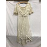 An Edwardian cream lace over dress with delicate needle work embellishments and Brussels tapelace.
