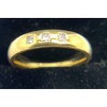 An 18ct yellow gold band set with 3 diamonds. Size N. Weight 5.6gms.Condition ReportGood condition.