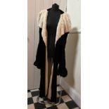 A c1910 black velvet and cream fur long coat with gathered smocked sleeves and cream lining.