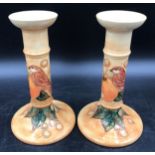 A Moorcroft pair of candle sticks decorated with birds and fruit 20.5cms h and impressed base