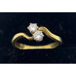 An 18ct two stone cross over diamond ring. Size K/L. 2.3gms.Condition ReportGood condition.