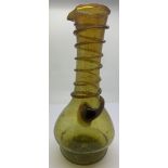 An olive green long neck glass jug with a spiral of green glass rising up the neck to the pourer