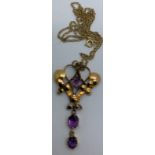 A 9ct gold Art Nouveau pendant set with 3 purple stones on a 9ct gold chain. 43cms l. Weight 2.