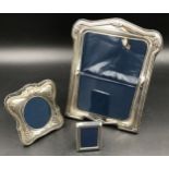 Three hallmarked silver photo frames. Largest Sheffield 1996 24cms h x 18cms w, floral embossed