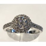 A STUNNING CONTEMPORARY 18CT WHITE GOLD DIAMOND HALO RING, with a centre diamond .60cts, total