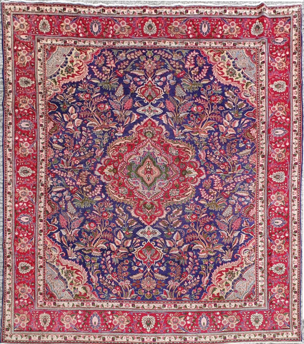 A VINTAGE HAND KNOTTED PERSIAIN TABRIZ FLOOR RUG, with multiple borders, a centre blue ground with