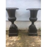 A PAIR OF CAST IRON GARDEN URNS