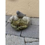 A STONE GARDEN ORNAMENT / BIRD BATH, in the form of two hands open with a bird seated upon them