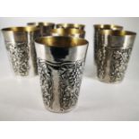 A SET OF SEVEN SILVER TUMBLERS, marked 800, continental silver, each decorated with fruiting vine