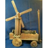 A RARE 19TH CENTURY ANTIQUE CHILD’S PULL ALONG TOY IN THE FORM OF A WINDMILL, the sail turns when