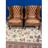A FINE PAIR OF LEATHER BUTTON BACKED WING ARM CHAIRS, with beaded detail to upholstery, raised on