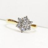 A SPARKLING 18CT SOLD GOLD DIAMOND CLUSTER RING, with seven sparking brilliant cut diamonds set in a