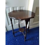 AN OCTAGONAL OCCASIONAL TABLE, raised on turned legs, united by lower pot shelf, 27 inches tall x 34