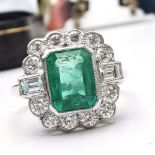 A PLATINUM EMERALD & DIAMOND STATEMENT RING, with natural cushion cut Emerald with a beautiful