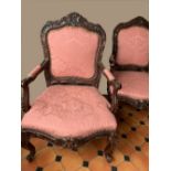 A GOOD PAIR OF ARMCHAIRS, with carved floral design to the frame,