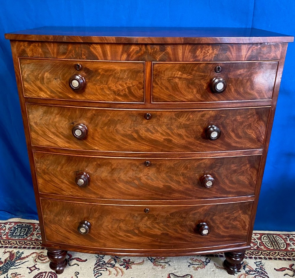 A VERY FINE REGENCY BOW FRONTED FEATHER VENEERED MAHOGANY CHEST O