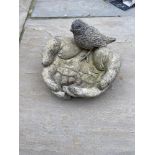 A STONE BIRD BATH, in the form of a pair of open hands with a bird seated on them