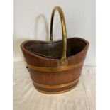 AN OLD BRASS BOUND PEAT BUCKET, with original liner, with a handle at one side for tipping out, 38cm