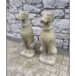 A PAIR OF STONE GARDEN ORNAMENTS IN THE FORM OF SITTING HOUNDS